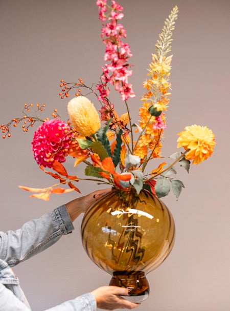 Kunstbloemenboeket met herfst zijden bloemen in amberkleur mondgeblazen glazen vaas Fridio met hand