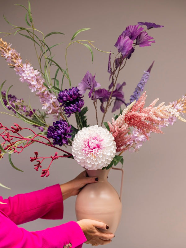 zijden bloemen in nude handvatvaas in hand gepresenteerd ivm afmeting