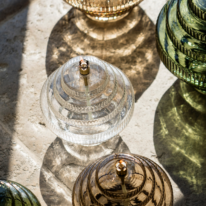 Twin Olielamp van Peri Living in 3 kleuren afgebeeld: transparant, groen en champagne brass. Verkrijgbaar bij BloomFever