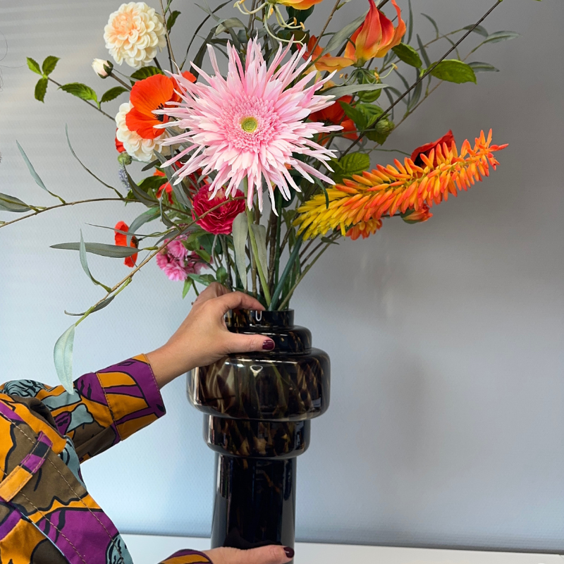 In hand gepresenteerd: Zijden boeke4t van BloomFever in de Emily pantervaas van glas. Mooie details zoals roze kunst Gerbera