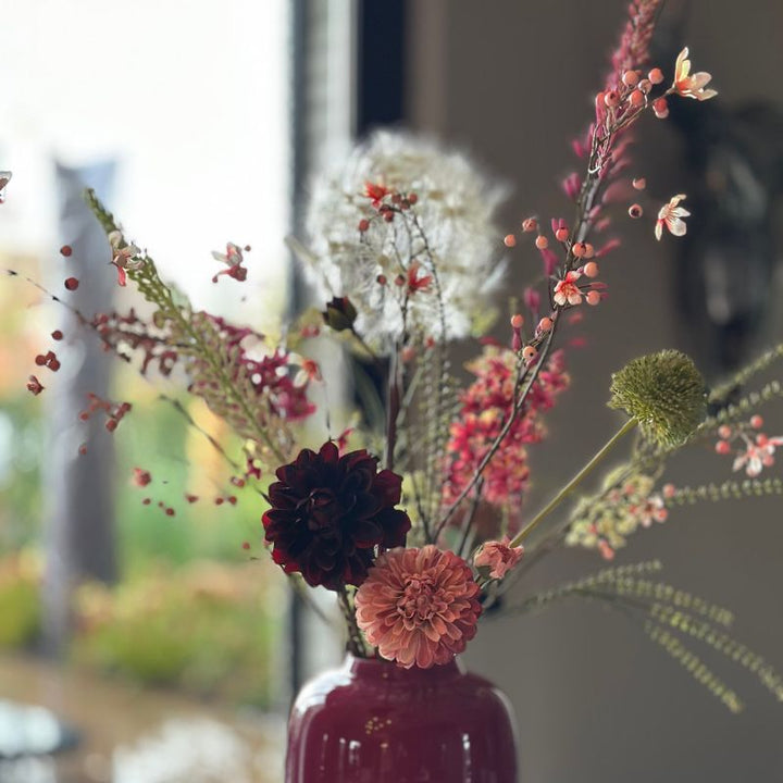 Detail van burgundy dahlia’s, witte dandelion en roze-witte eremus stelen uit boeket Wiesje.