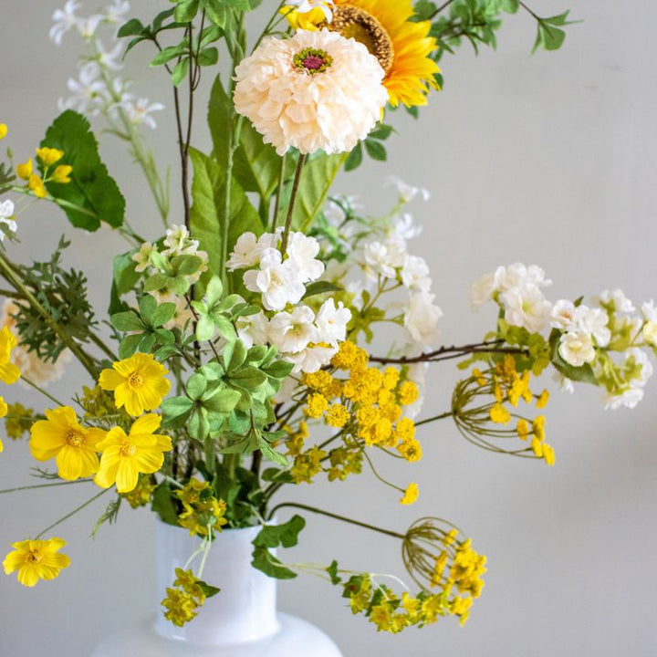 close up van kunstboeket aaf bestaande uit gele Zonnebloemen, witte dahlia's,
gele Gypsohilia's en witte jasmijntjes. zijden bloemen zijn te bestellen bij bloomfever